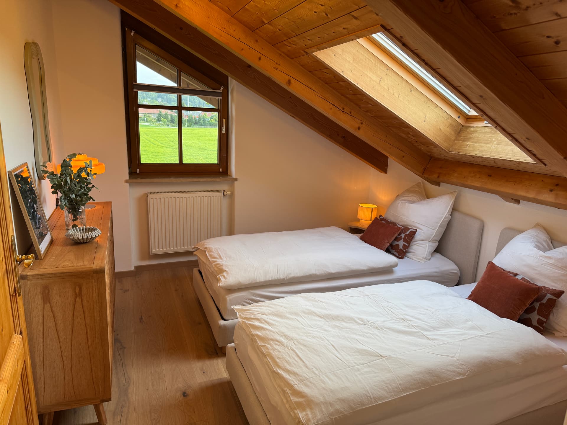 Zweites Schlafzimmer mit zwei Betten unter Dachschräge und Dachfenster