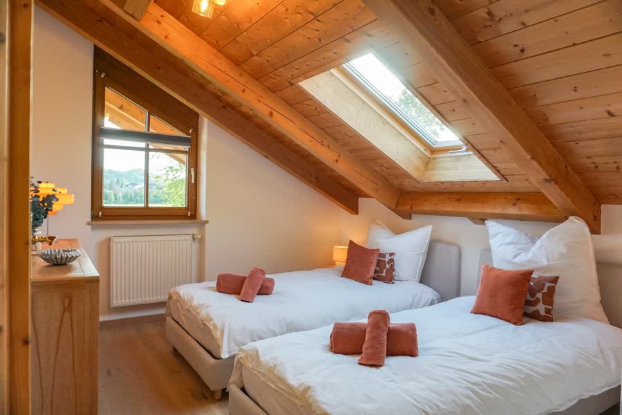 Zweites Schlafzimmer mit zwei Betten unter Dachschräge und Dachfenster
