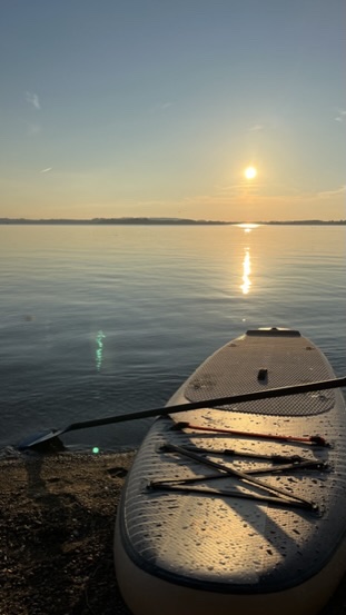 Stand-up-Paddle-Board am Ufer des Chiemsees bei Sonnenuntergang