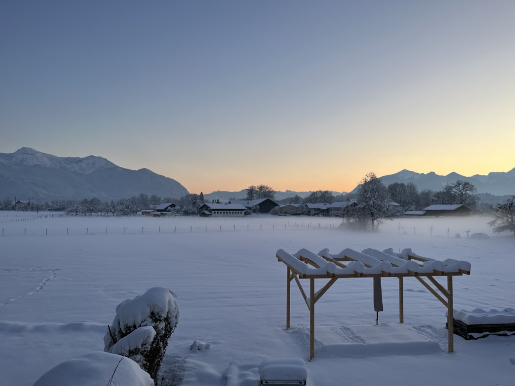 Winterabend mit Schnee und Blick auf die Chiemgauer Alpen