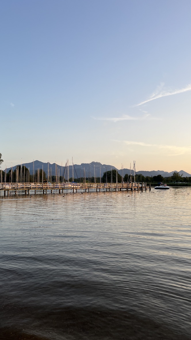 Bootssteg am Chiemsee im Abendlicht mit Blick auf die Chiemgauer Alpen